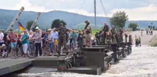  a Militares ajudando a população a atravessar o rio.