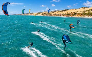 Kitesurf E Wingfoil No Ceará: O Vento Que Move R$ 1,66 Bilhão E Ainda Espera Por Regras Aerial Action Photo Of Kitesurfers And Wingfoil Riders Racing Across Turquoise Ocean Water With Strong Wind-Filled Kites…