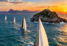 Regata Santos-Rio terá nova chegada na Ilha Rasa em 2026 Veleiros oceânicos de competição navegando em mar aberto perto de uma pequena ilha rochosa na costa do Rio de Janeiro, a…
