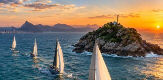 Veleiros oceânicos de competição navegando em mar aberto perto de uma pequena ilha rochosa na costa do Rio de Janeiro, a…