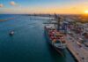 Porto de Suape ganha novas profundidades pela Marinha Vista aérea do porto de Suape com navio porta-contêineres atracado